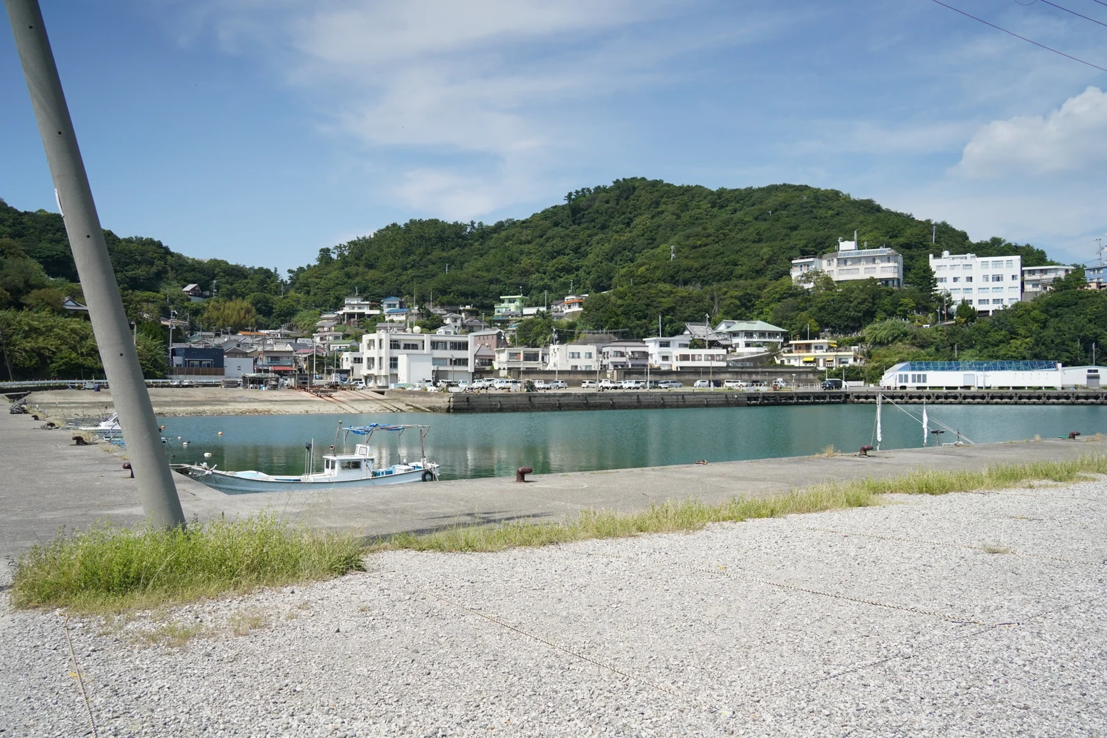 和歌山市田野の田ノ浦漁港。水面の向こうに山と家並み